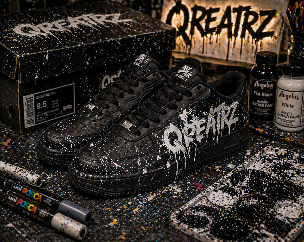 Custom black TREADZ sneakers with graffiti “CREATE” design on a paint-splattered studio workspace
